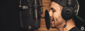chico con gorra cantando con un micrófono en un estudio de grabación